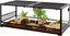 Glass reptile terrarium with mesh top, plants, cork logs, and soil substrate for reptiles