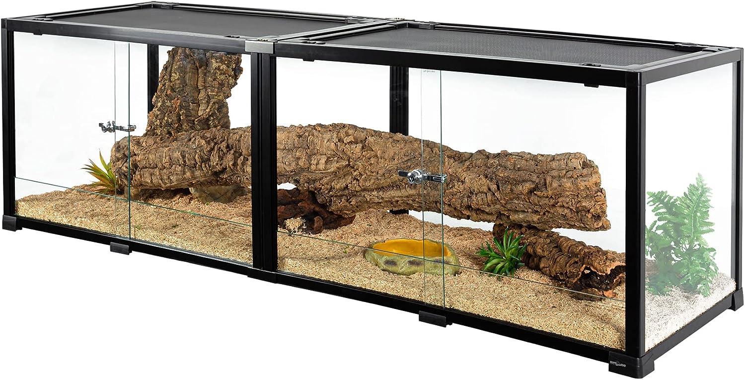 Large glass reptile terrarium with sliding doors, logs, artificial plants, and sand substrate