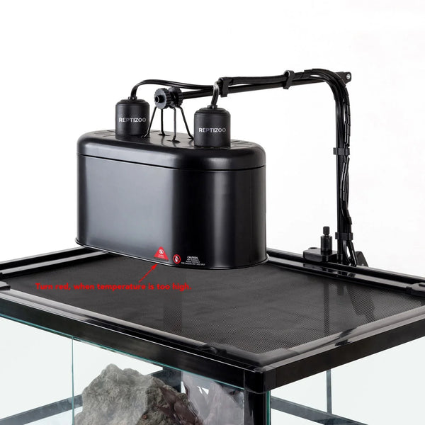 Reptile terrarium with black UVB heat lamp fixture on mesh lid, temperature warning label visible
