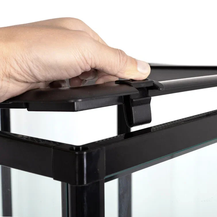 Hand opening secure latch on black-framed reptile terrarium glass lid