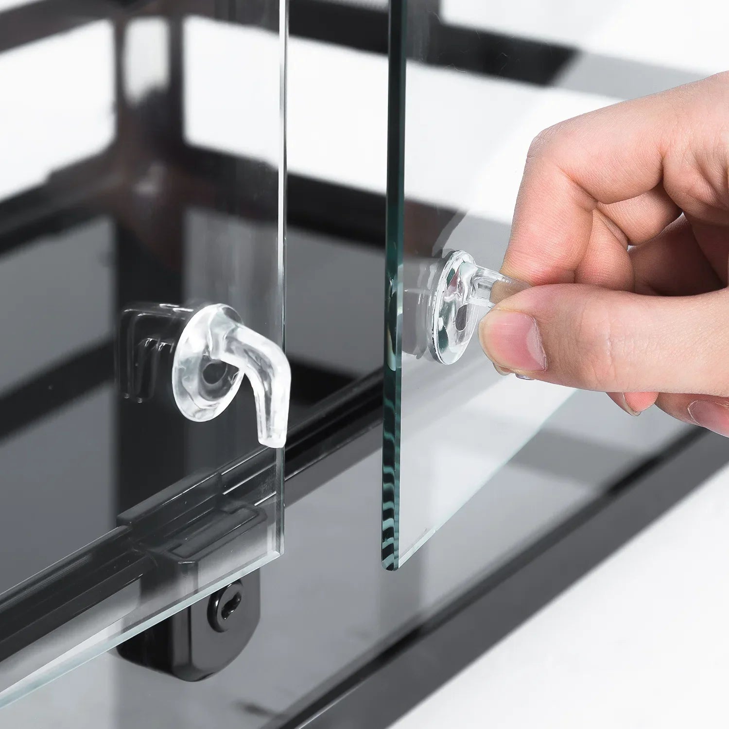 Sliding glass door handle on a reptile terrarium being opened by hand