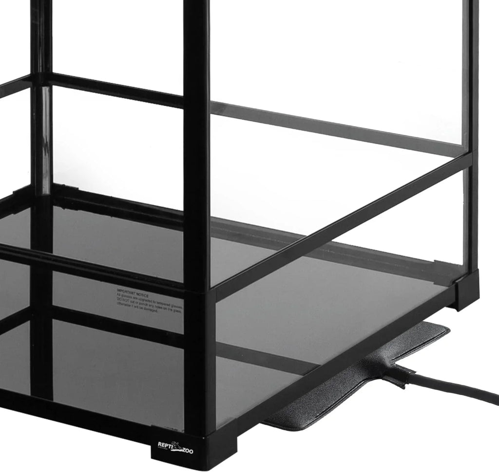 Glass reptile terrarium with black metal frame and under-tank heat pad setup