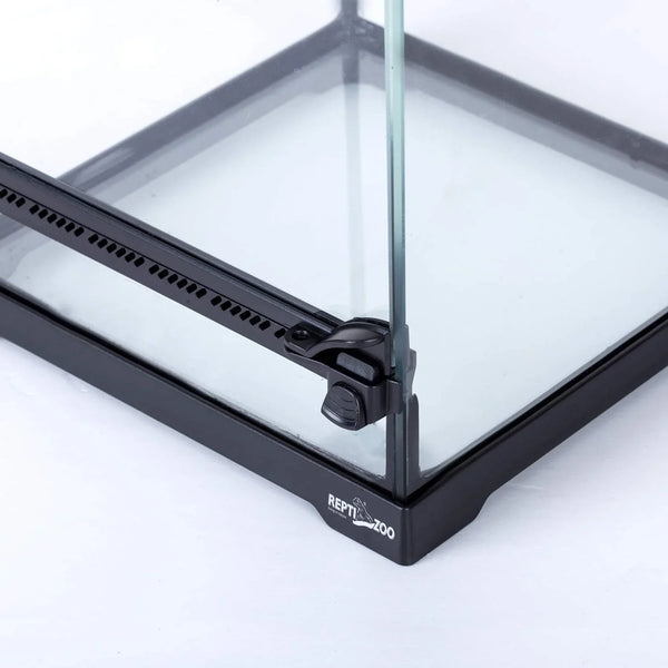 Close-up of glass reptile terrarium corner with secure lock and ventilation strip