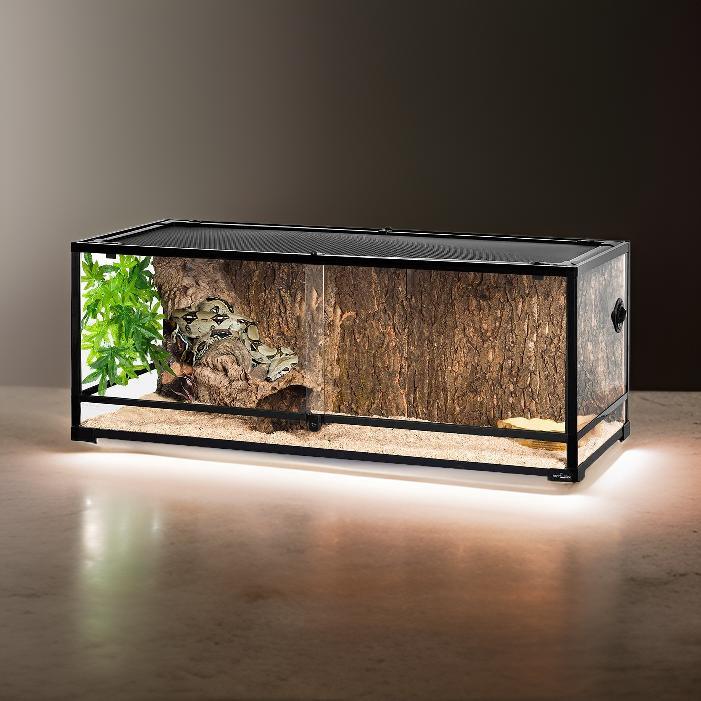 67 gallon glass reptile enclosure with wood accents, substrate, and artificial plants