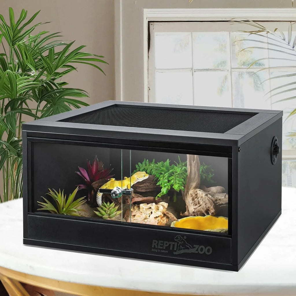 Glass reptile terrarium with mesh lid, plants, rocks, and a yellow lizard inside