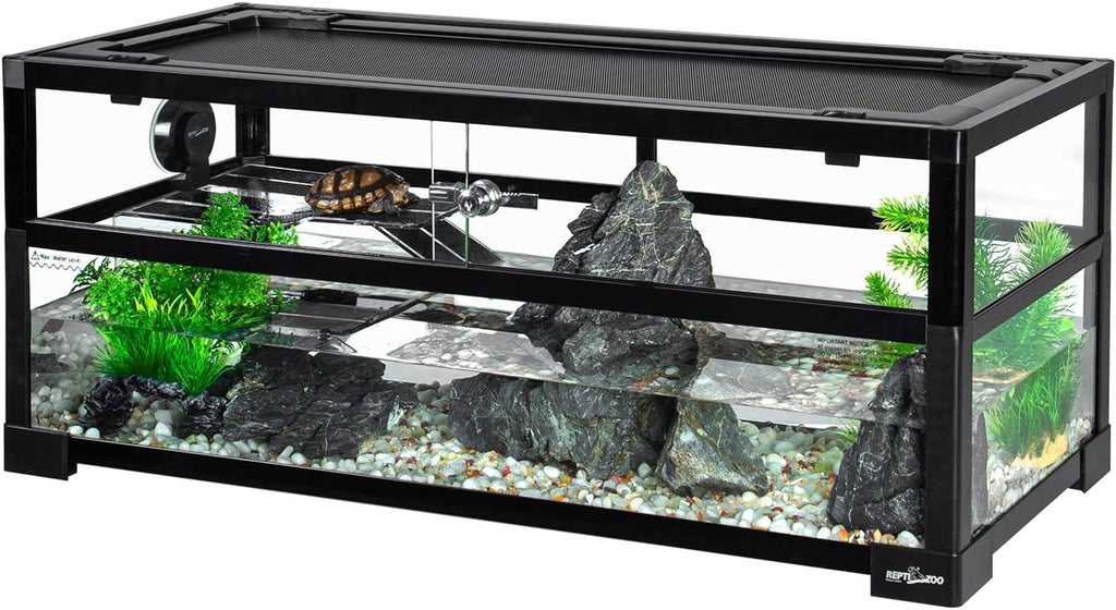 Glass reptile terrarium with basking platform, rocks, plants, and a turtle basking under a heat lamp