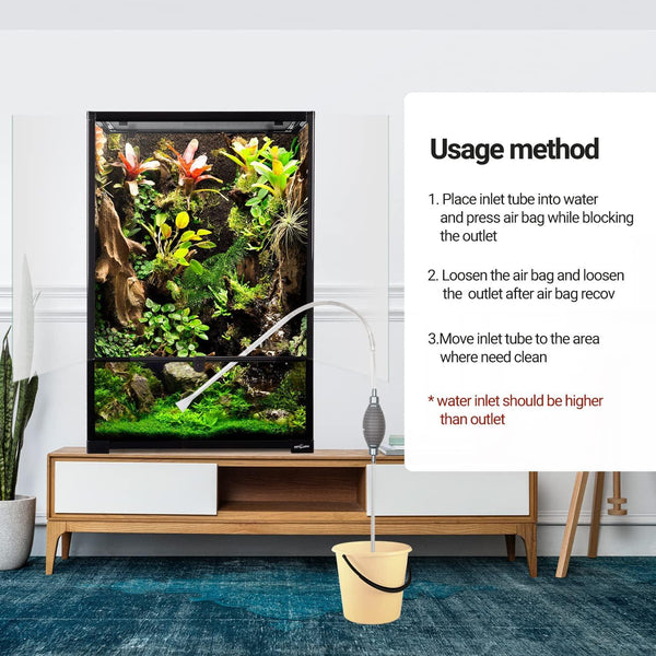 Vertical reptile terrarium with lush plants, siphon cleaning tube connected to bucket, usage instructions shown