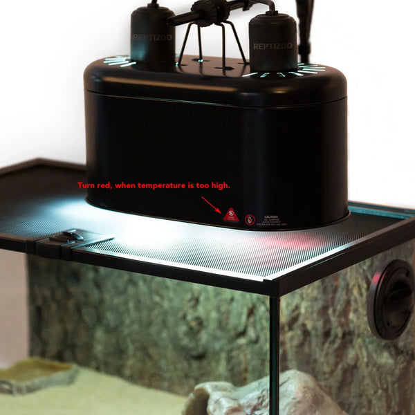 Black reptile tank heat lamp with temperature warning indicator on terrarium mesh lid.