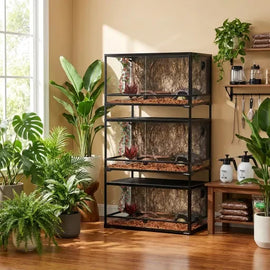 Stacked reptile terrariums with tropical plants in a sunlit room, reptile habitat setup