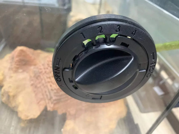 Black adjustable cable pass-through grommet installed in glass reptile terrarium